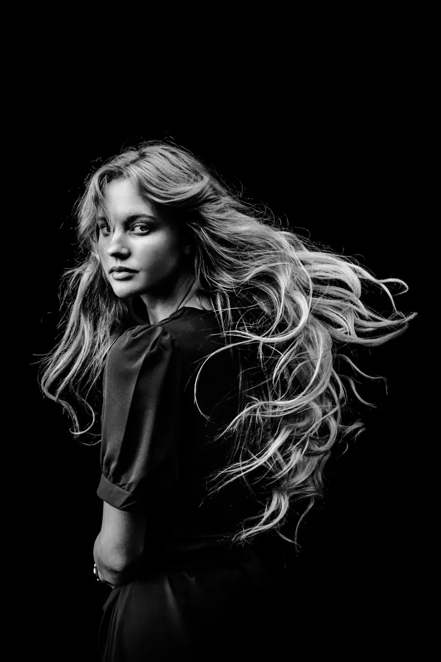 Ritratto in bianco e nero di una donna con i capelli in movimento